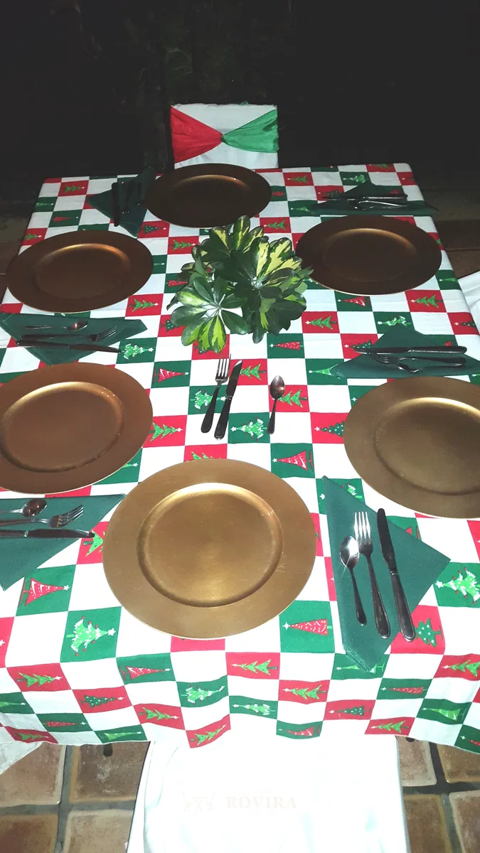 Platos base dorados sobre camino navideño rojo, verde y blanco