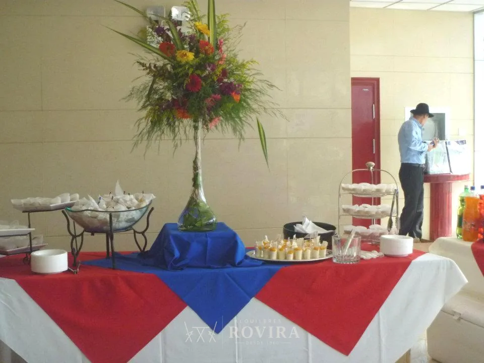 Mesa redonda con montaje patrio rojo, azul y blanco y centro de mesa, temática típica costarricense