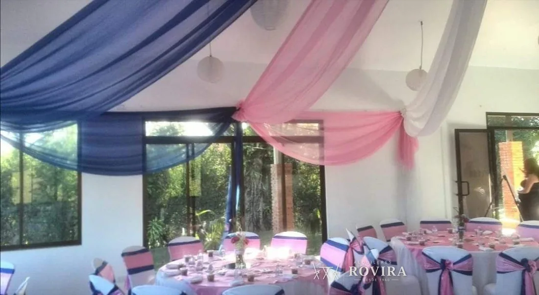 Techo de tela azul marino, rosa y blanco en salón moderno con ventanales