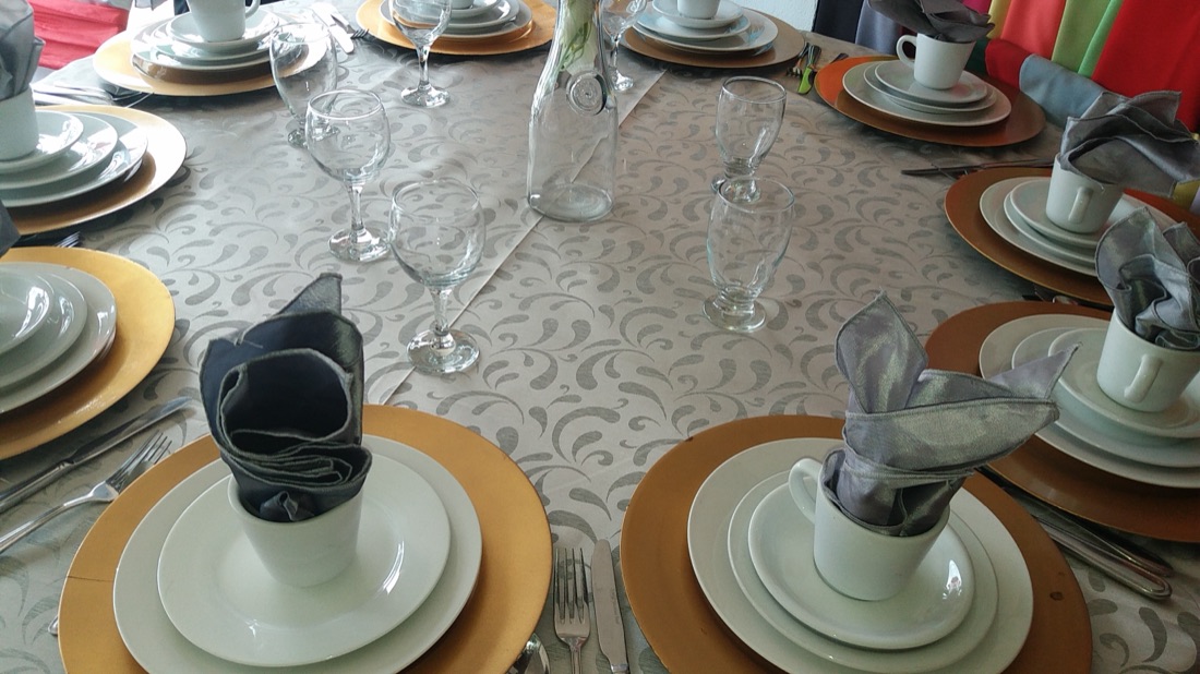 Mesa vestida en gris damasco con botella decorativa de centro y copas de vino