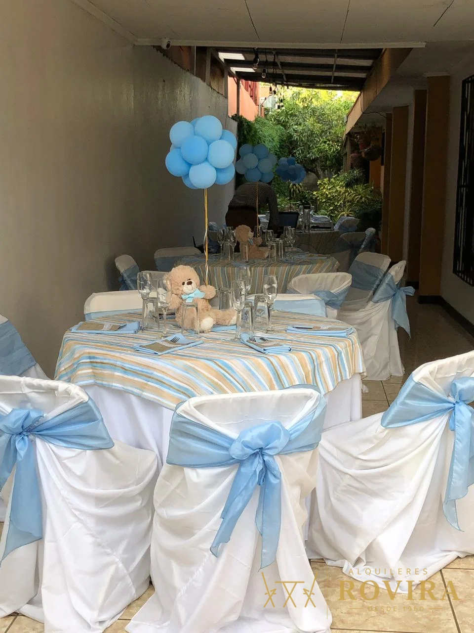 Baby shower de niño con centro de osito de peluche, lazos celestes y globos azules