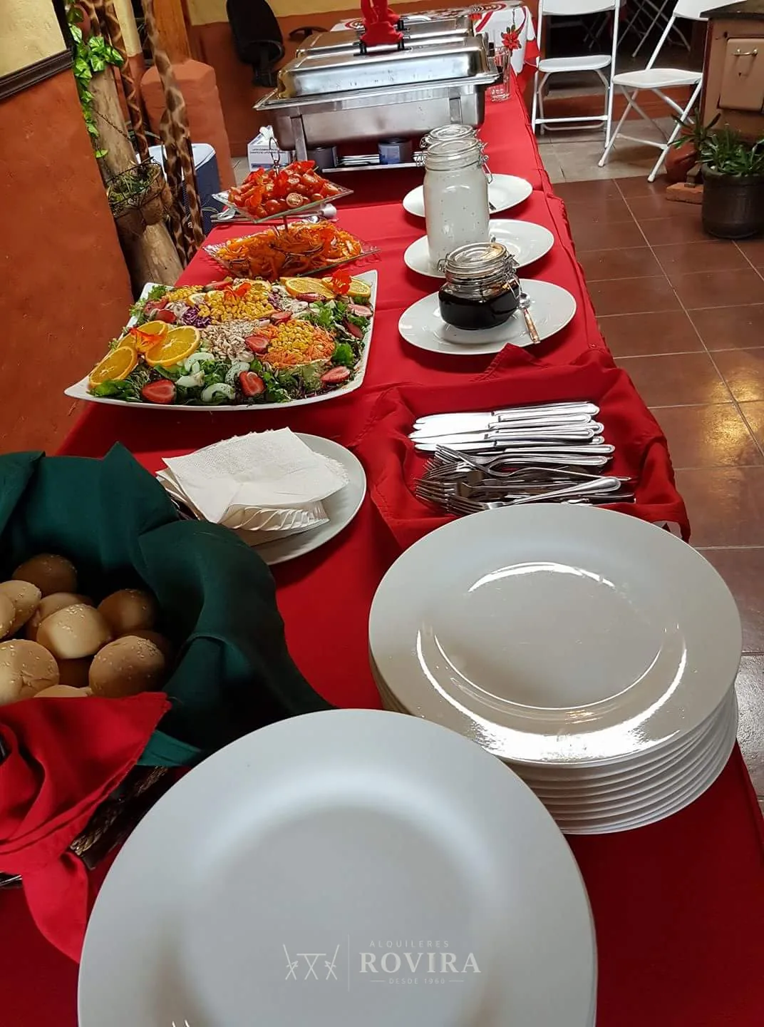 Buffet con bandejas de comida y platos de servicio, catering de evento