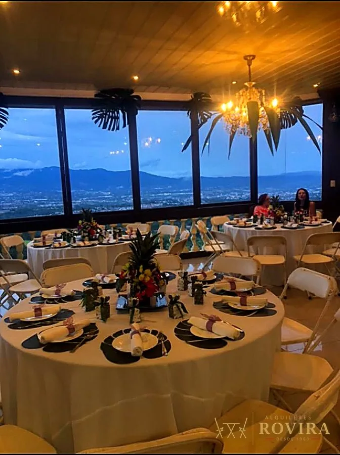 Salón con ventanales y vista panorámica, mesas montadas para banquete