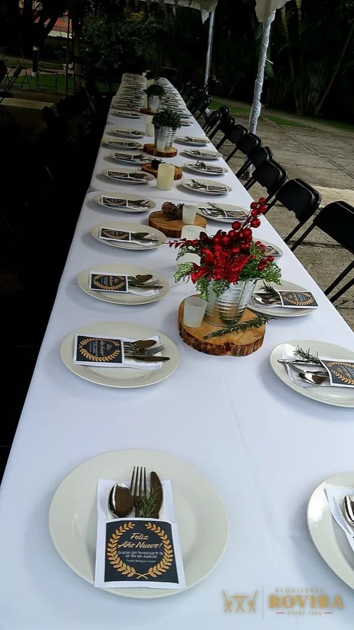 Mesa imperial larga con vajilla completa y servilletas rojas, montaje elegante