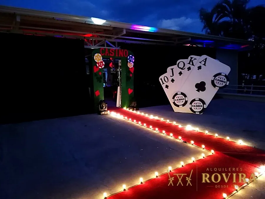 Entrada temática de casino con cartas y camino de luces rojas