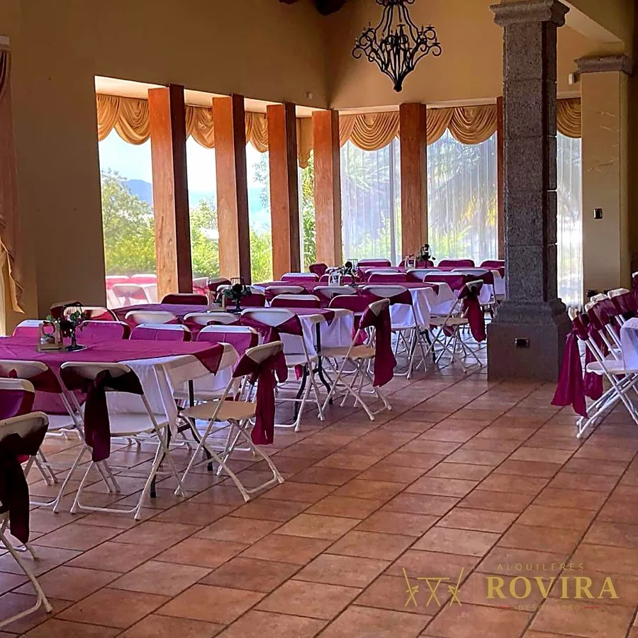 Salón colonial con mesas redondas vestidas en rosa