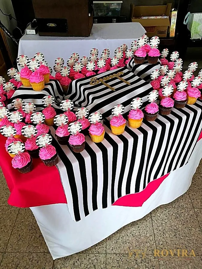 Cupcakes en exhibidor con mantel de rayas blanco y negro