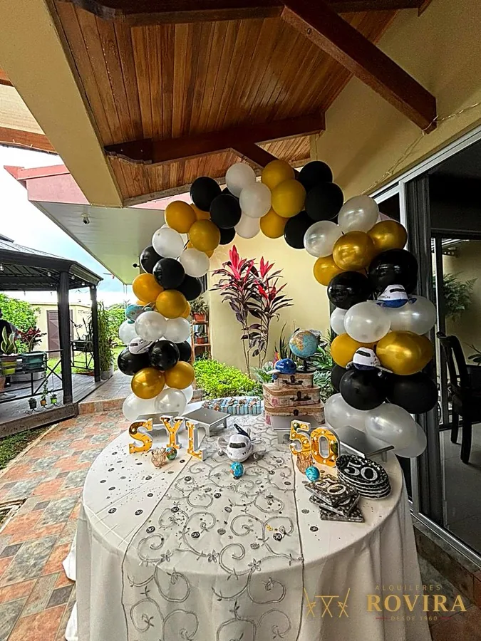 Arco de globos dorado, negro y blanco con mesa coctelera