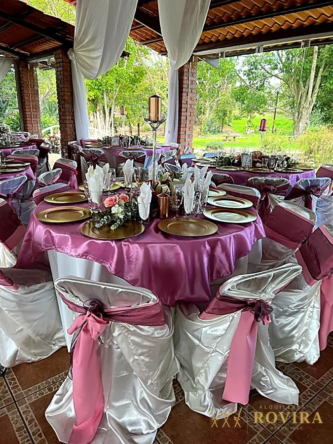 Salón con mesas redondas en satén rosa, montaje elegante