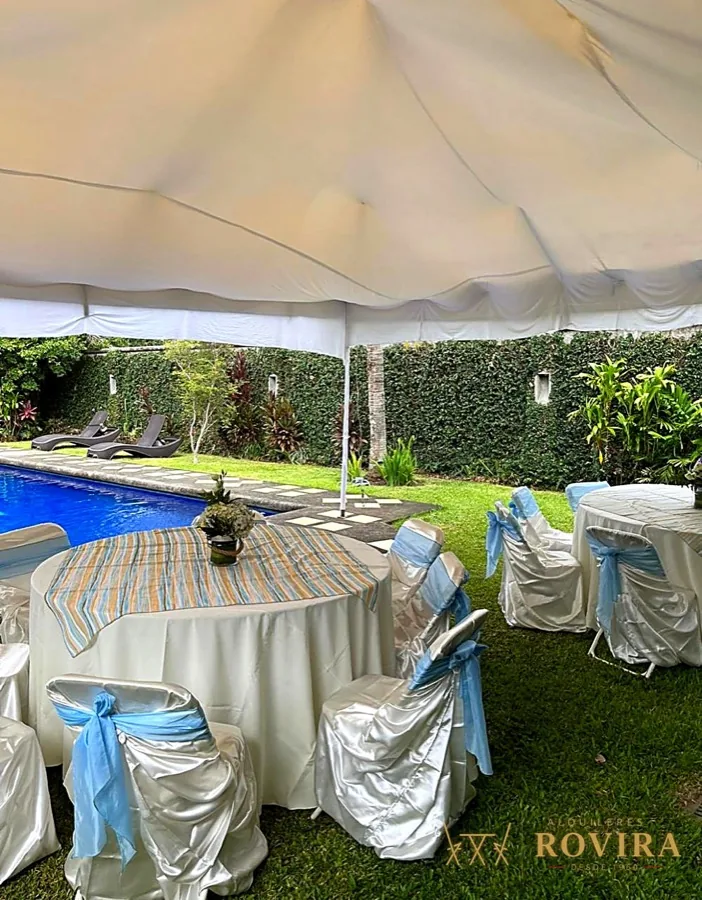 Toldo blanco con mesas redondas junto a piscina